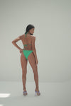 Model in green tanga bikini bottoms